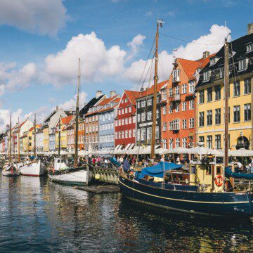 Idylliske Nyhavn i København med farverige bygninger og både – en perfekt beliggenhed i ferielejligheder i København