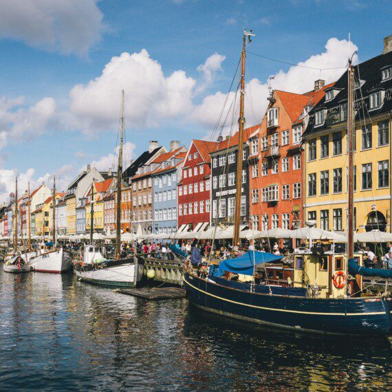 Idylliske Nyhavn i København med farverige bygninger og både – en perfekt beliggenhed i ferielejligheder i København