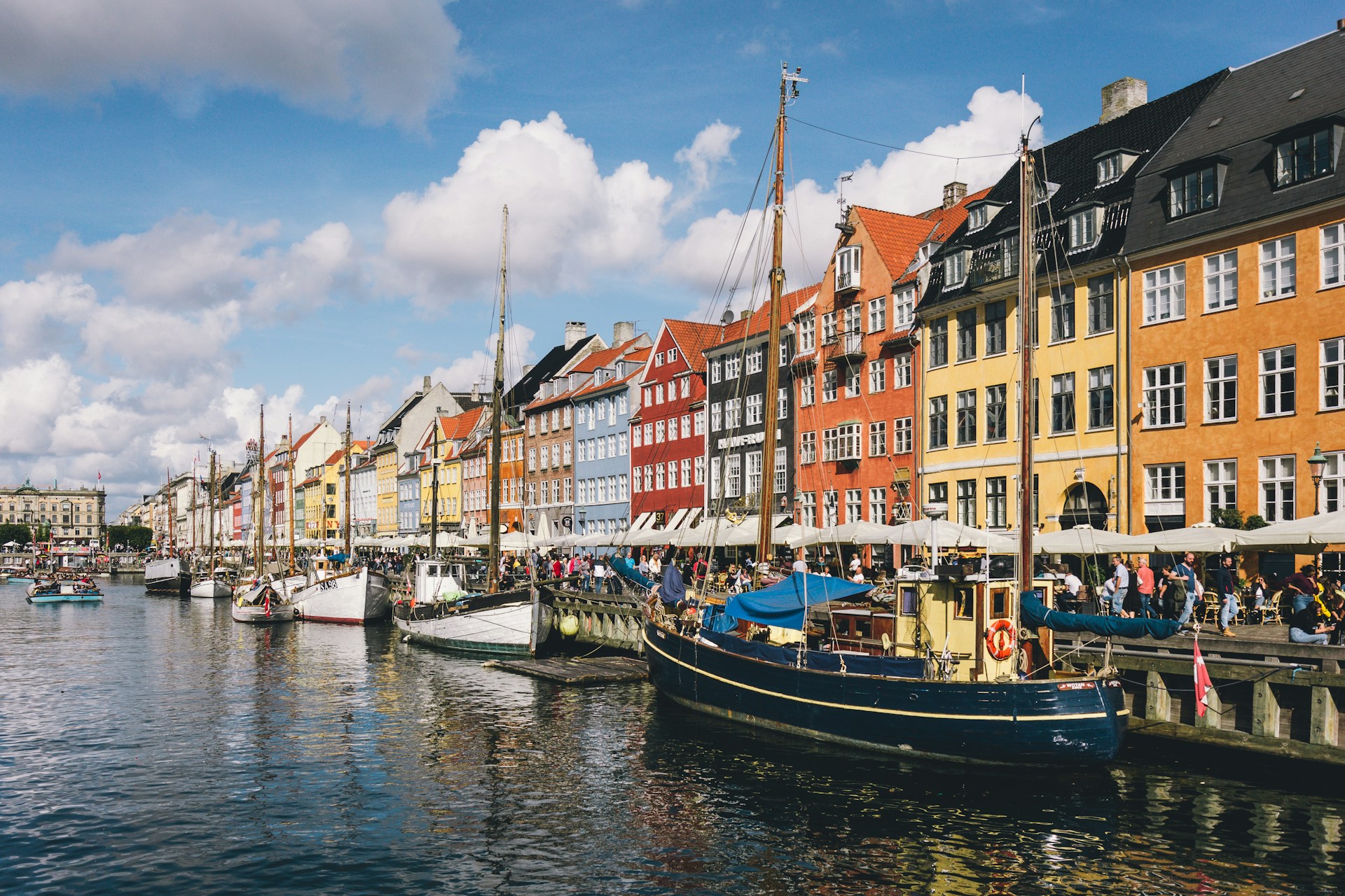 Idylliske Nyhavn i København med farverige bygninger og både – en perfekt beliggenhed i ferielejligheder i København