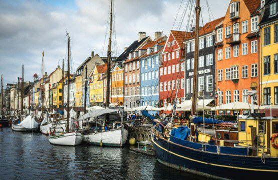 Charmerende Nyhavn med farverige huse og turister, et populært spisested tæt på ferieboliger i København